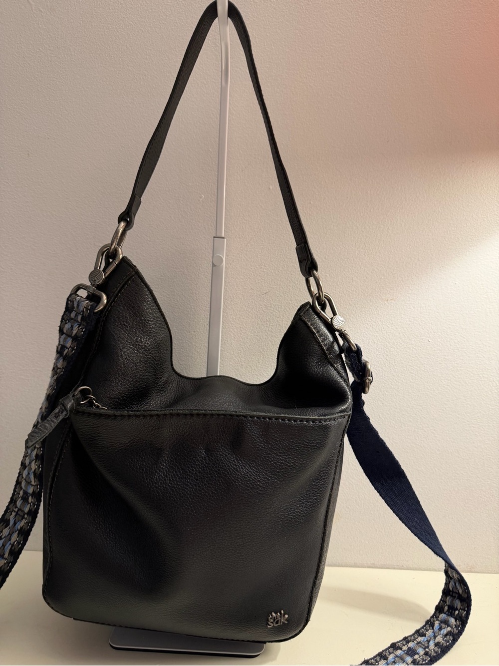 The Sak soft black leather shoulder bag with guitar crossbody strap.